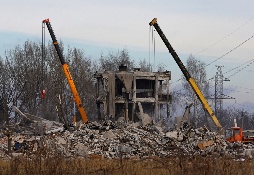 Workers remove debris of a destroyed building purported to be a vocational college used as temporary accommodation for Russian soldiers, dozens of whom were killed in a Ukrainian missile strike, January 4, 2023. Reuters/Alexander Ermochenko