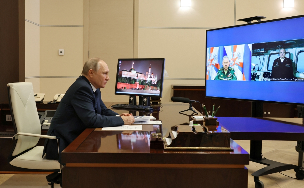 Russian President Vladimir Putin listens to the report by Defence Minister Sergei Shoigu and Commander of the Admiral Gorshkov frigate Igor Krokhmal before a ceremony to launch the Admiral Gorshkov frigate to the combat mission, via video link in Moscow, Russia, on January 4, 2023. Sputnik/Mikhail Klimentyev/Kremlin via REUTERS