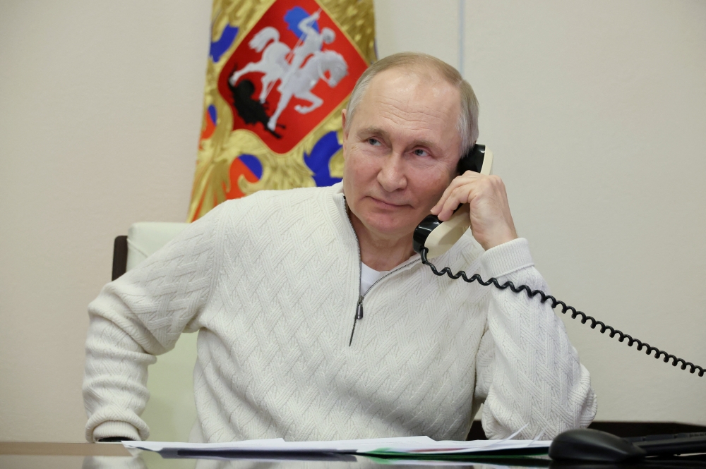 Russian President Vladimir Putin speaks on the phone with David Shmelev from Stavropol Region, a 7-year-old participant of a New Year's and Christmas charity event, at the Novo-Ogaryovo state residence outside Moscow, Russia, January 5, 2023. (Sputnik/Mikhail Klimentyev/Kremlin via REUTERS)