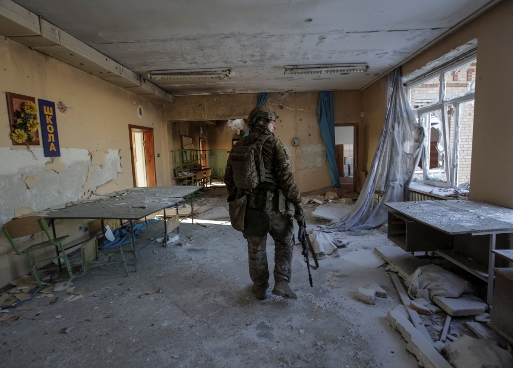 A Ukrainian serviceman is seen in a destroyed building of a school at a frontline, amid Russia's attack on Ukraine, in Donetsk region, Ukraine on January 7, 2023. REUTERS/Anna Kudriavtseva