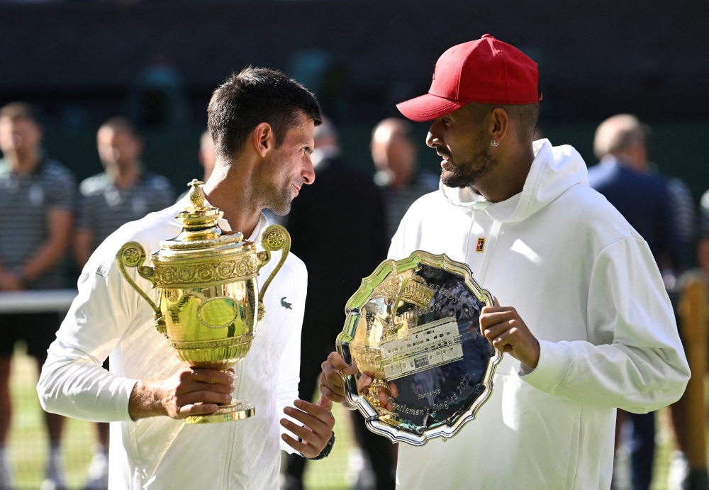 Serbia's Novak Djokovic poses with the trophy after winning the Wimbledon men's singles final alongside runner up Australia's Nick Kyrgios, July 2022. REUTERS/Toby Melville/File Photo