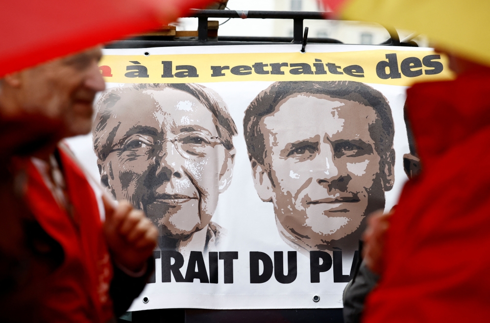 A banner depicting French Prime Minister Elisabeth Borne and French President Emmanuel Macron is pictured as protestors attend a demonstration against pension reform in Rennes on the day the French government unveils its pension reform, France, on January 10, 2023. REUTERS/Stephane Mahe