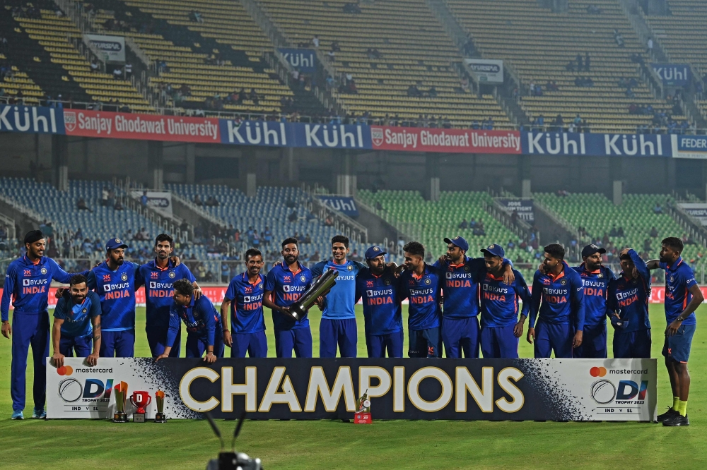 India's players pose with the trophy after winning the third and final one-day international (ODI) cricket match between India and Sri Lanka at the Greenfield International Stadium in Thiruvananthapuram on January 15, 2023. (Photo by Arun SANKAR / AFP)