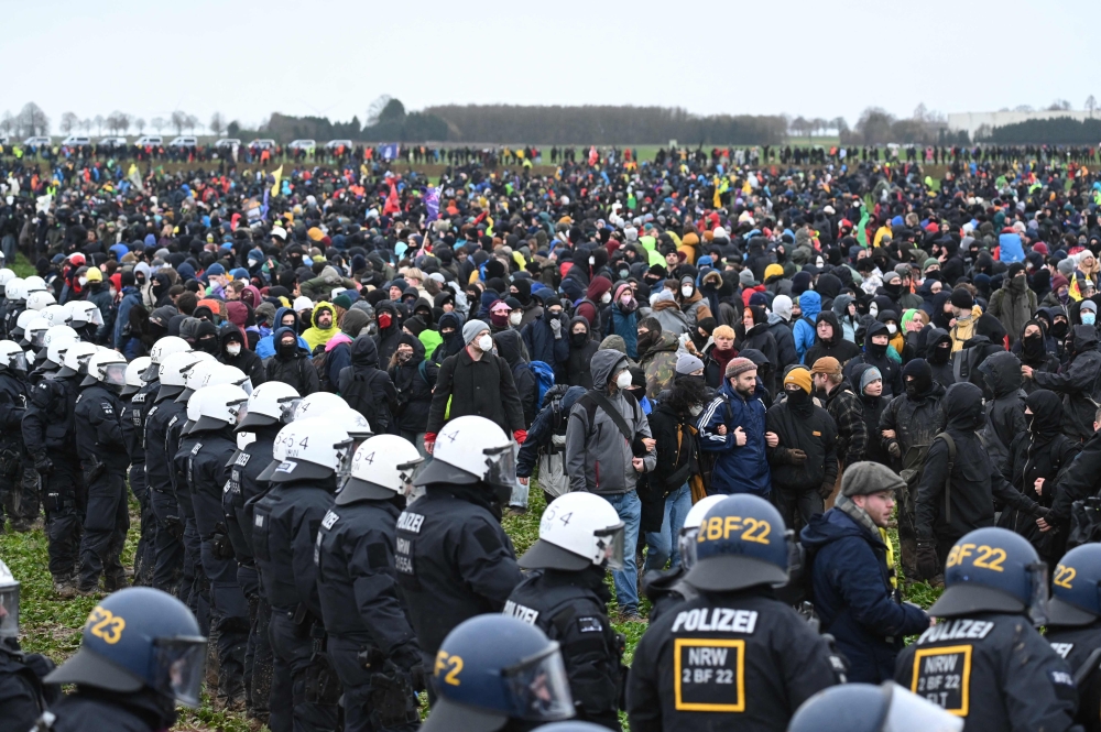 Police face protesters during a large-scale protest to stop the demolition of the village Luetzerath to make way for an open-air coal mine extension on January 14, 2023.  (Photo by INA FASSBENDER / AFP)