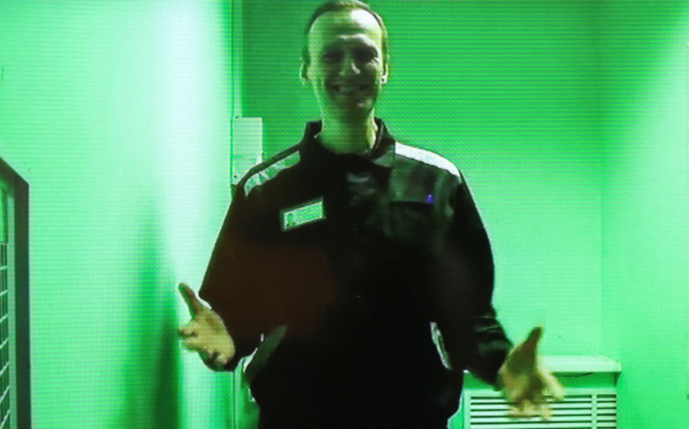 Russian opposition politician Alexei Navalny is seen on a screen via a video link before a court hearing to consider his claims against the administration of a penal colony where he is serving his sentence after being found guilty of parole violations, fraud and contempt of court charges, in the town of Kovrov, Russia on October 7, 2022.  File Photo / Reuters