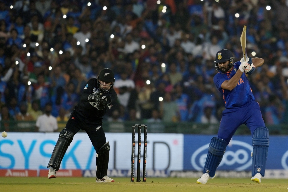 India's captain Rohit Sharma (right) plays a shot during the second one-day international (ODI) cricket match between India and New Zealand at the Shaheed Veer Narayan Singh International Cricket Stadium in Raipur on January 21, 2023. (Photo by Money SHARMA / AFP)