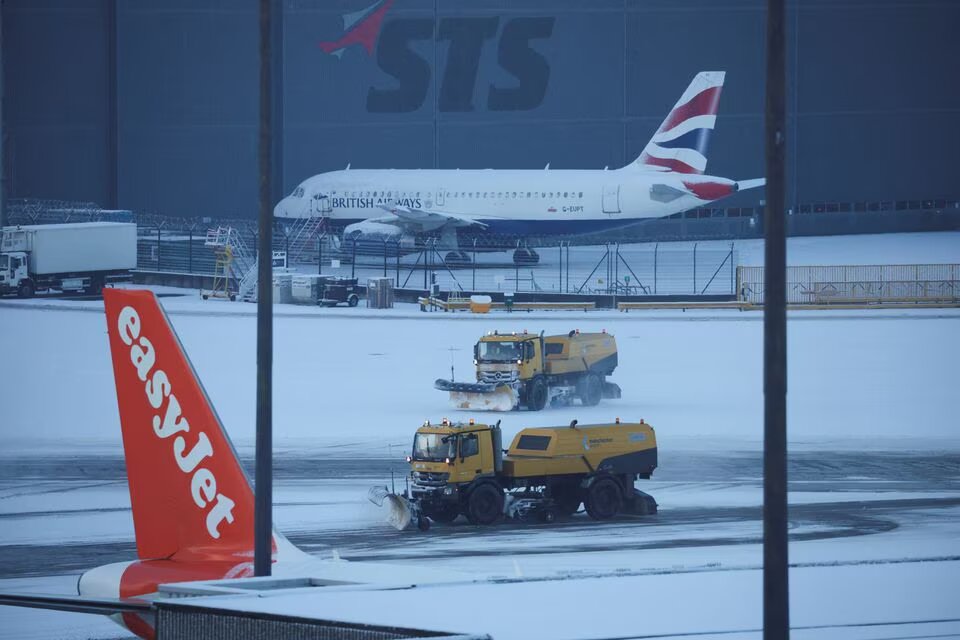 Snow ploughs clear snow from the airfield after overnight snow forced the closure of Manchester airport, in Manchester, Britain, on January 19, 2023. REUTERS/Phil Noble
