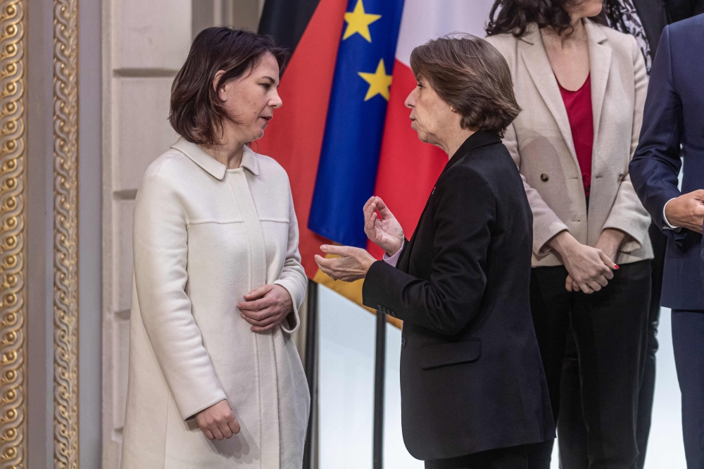 French Foreign and European Affairs Minister Catherine Colonna (right) speaks with German Federal Minister for Foreign Affairs Anna lena Baerbock as they arrive for a group picture prior to a cabinet meeting, as part of the celebration of the 60th anniversary of the signing of the Elysee Treaty, to seal reconciliation between France and West Germany, 18 years after the Second World War at the presidential Elysee Palace in Paris on January 22, 2023.  (Photo by Christophe PETIT TESSON / POOL / AFP)
