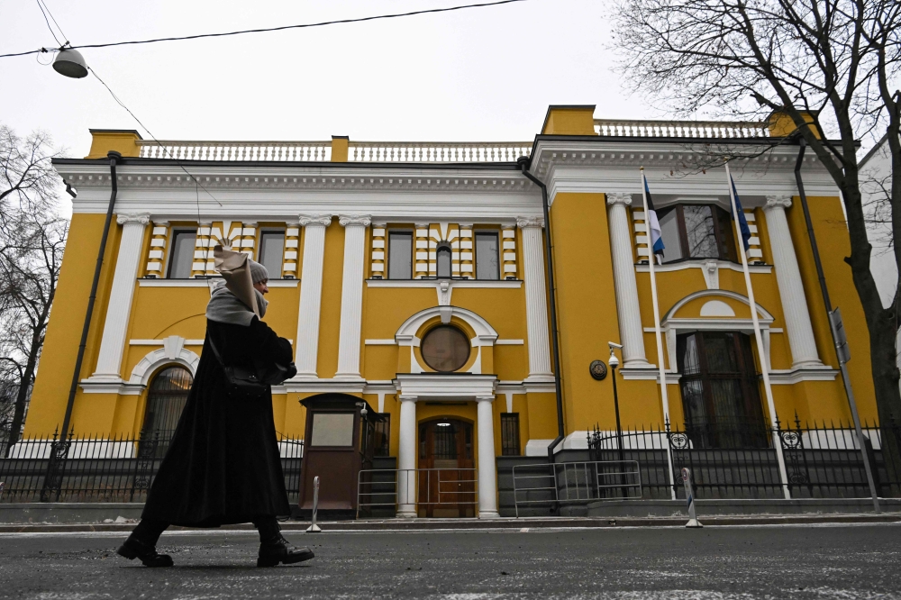 A woman walks past the Estonian embassy in Moscow on January 23, 2023. - Moscow on January 23 downgraded diplomatic relations with Estonia and ordered its ambassador to leave Russia, accusing the Baltic country of 