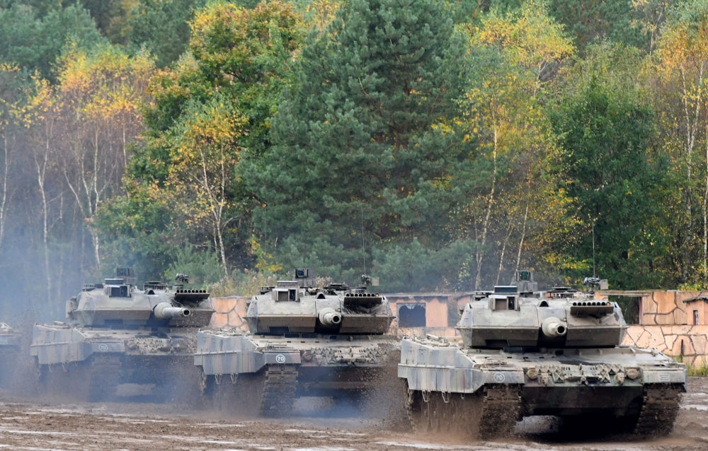 This file photo taken on October 13, 2017 shows an armored unit with Leopard 2 A7 main battle tanks of the German armed forces Bundeswehr driving through the mud in the context of an informative educational practice 