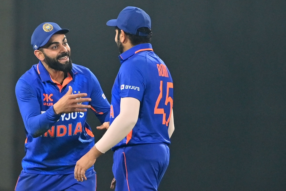 India's captain Rohit Sharma (right) and his teammate Virat Kohli celebrate after the dismissal of New Zealand's captain Tom Latham (not pictured) during the third and final one-day international (ODI) cricket match between India and New Zealand at the Holkar Cricket Stadium in Indore on January 24, 2023. (Photo by Punit PARANJPE / AFP)