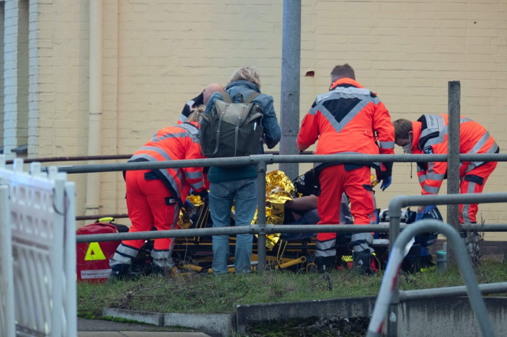 Rescue workers attend to a wounded person near a railway crossing at the station of Brokstedt, northern Germany, on January 23, 2023, after a man stabbed people on a regional train between the cities of Hamburg and Kiel, killing two people and wounding several others. (Photo by Jonas Walzberg / dpa / AFP) / Germany OUT
