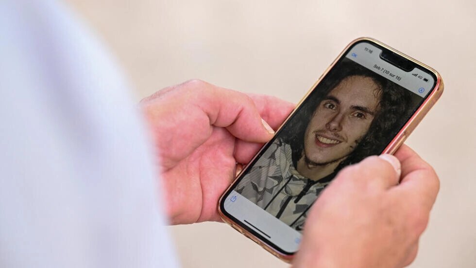 A photo of French national Sebastien Raoult, displayed on the phone of his father, Paul Raoult, in Épinal, eastern France, on August 1, 2022. Jean-Christophe Verhaegen / AFP
