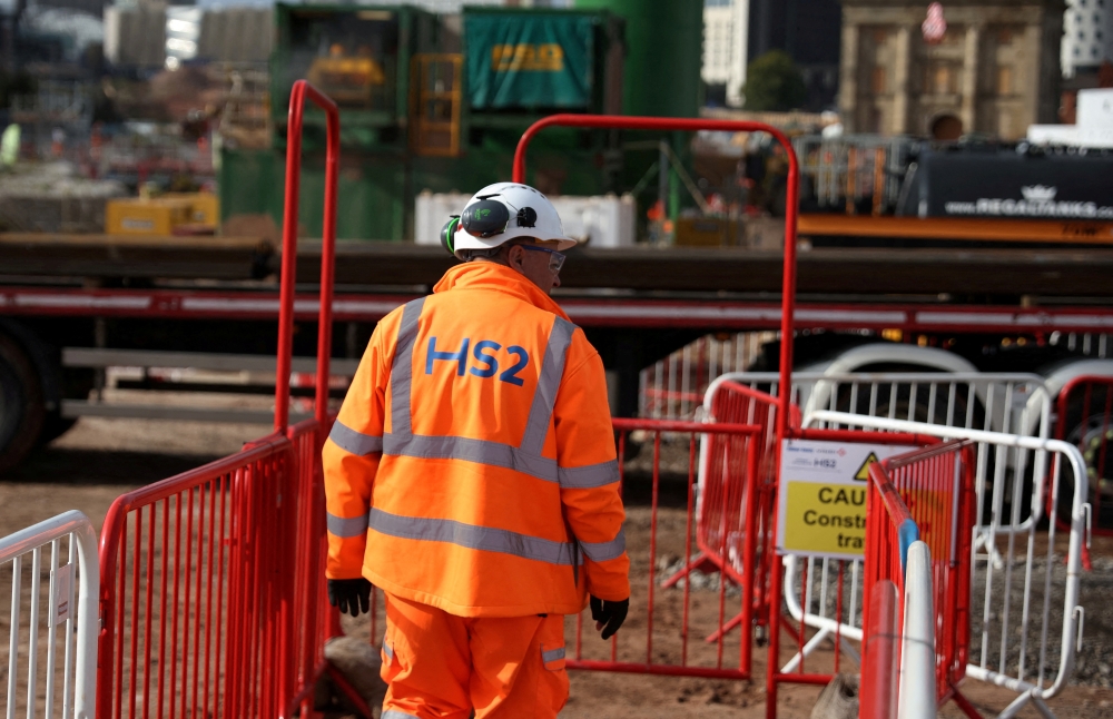 A worker walks along a walkway at the HS2 rail Curzon Street Station construction site in Birmingham, Britain, October 3, 2022. REUTERS/Phil Noble/File Photo