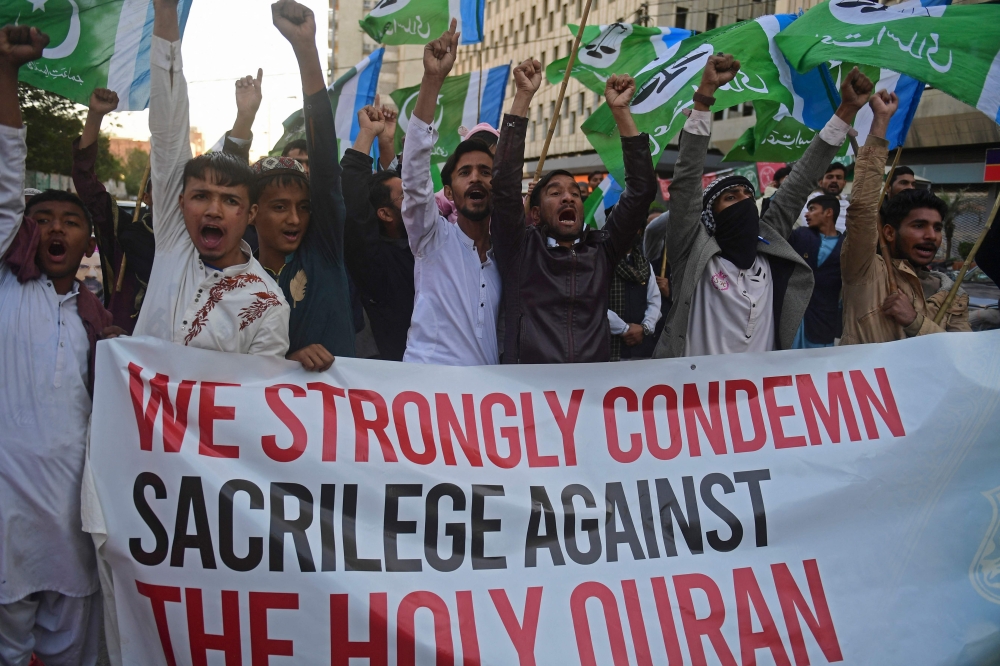 Jamaat-e-Islami (JI) party members chant slogans in a protest against the torching of the Holy Quran in Sweden over the weekend, in Karachi on January 26, 2023. (Photo by Asif Hassan / AFP)