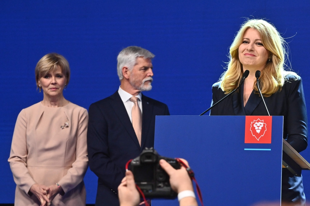 Presidential candidate Petr Pavel, former Chief of the General Staff of the Czech Army, and his wife Eva (left) listen to a speech by Slovakian President Zuzana Caputova during a press conference in Prague, Czech Republic on January 28, 2023, after Pavel became the fourth president of the Czech Republic according to official results.  (Photo by Michal Cizek / AFP)