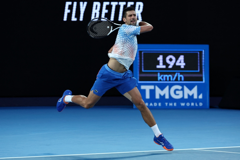 Serbia's Novak Djokovic hits a return against Greece's Stefanos Tsitsipas during their men's singles final match on day fourteen of the Australian Open tennis tournament in Melbourne on January 29, 2023. (Photo by DAVID GRAY / AFP)
