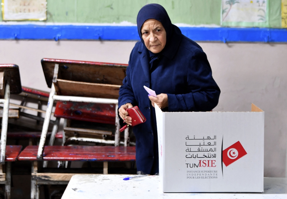 A Tunisian voter casts her ballot in the second round of parliamentary elections on January 29, 2023, in Ettadhamen, a working-class suburb west of the capital Tunis. (Photo by FETHI BELAID / AFP)