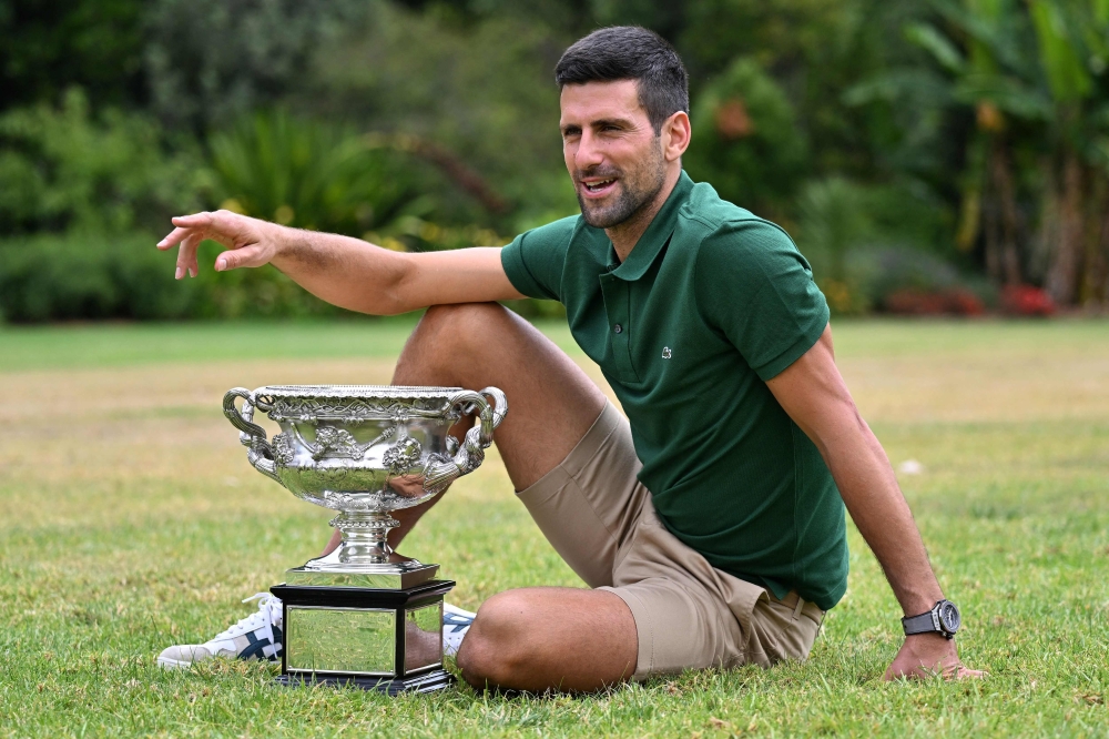 Serbia's Novak Djokovic celebrates with the Norman Brookes Challenge Cup trophy at the Government House a day after his victory against Greece's Stefanos Tsitsipas in the men's singles final match of the Australian Open tennis tournament in Melbourne on January 30, 2023. (Photo by Saeed Khan / AFP)