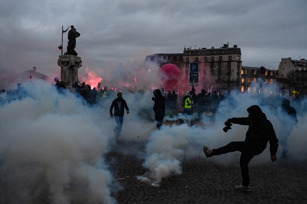 Protesters clash with police on the Place Vauban during a rally on a second day of nationwide strikes and protests over the government's proposed pension reform, in Paris on January 31, 2023. (Photo by Alain Jocard / AFP)