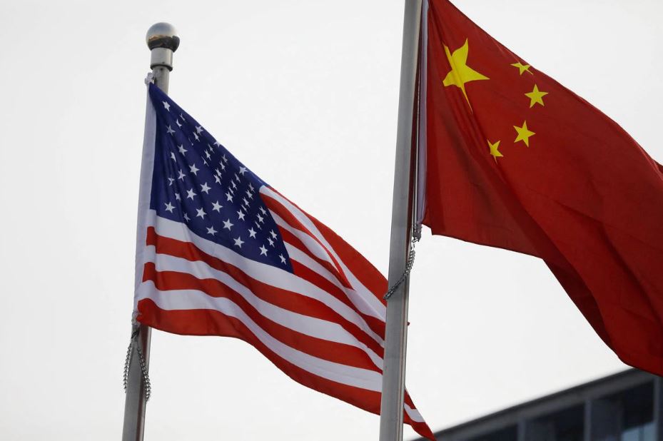 Chinese and US flags flutter outside the building of an American company in Beijing, China January 21, 2021. (REUTERS/Tingshu Wang)