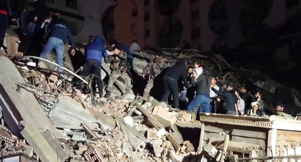 In this video grab from AFP TV taken on February 6, 2023, rescuers search for victims of a 7.8-magnitude earthquake that hit Diyarbakir, in southeastern Turkey, levelling buildings across several cities and causing damages in neighbouring Syria. (Photo by Mahmut BOZARSLAN / AFPTV / AFP)