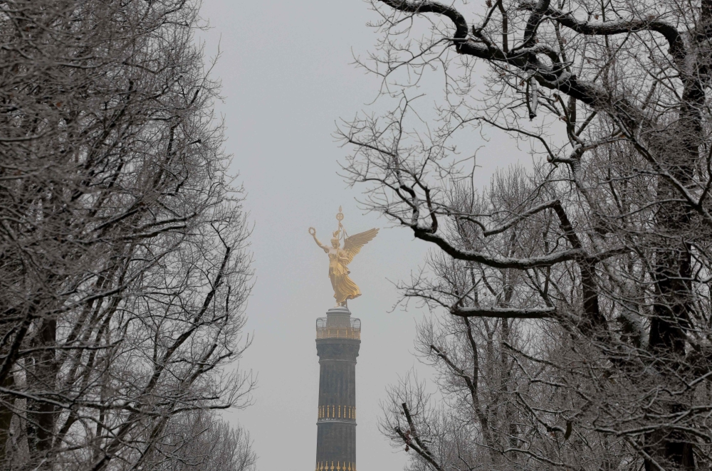 Berlin's landmark the Victory Column is seen behind snow-covered trees after snowfall on February 6, 2023 in the German capital. (Photo by Odd ANDERSEN / AFP)