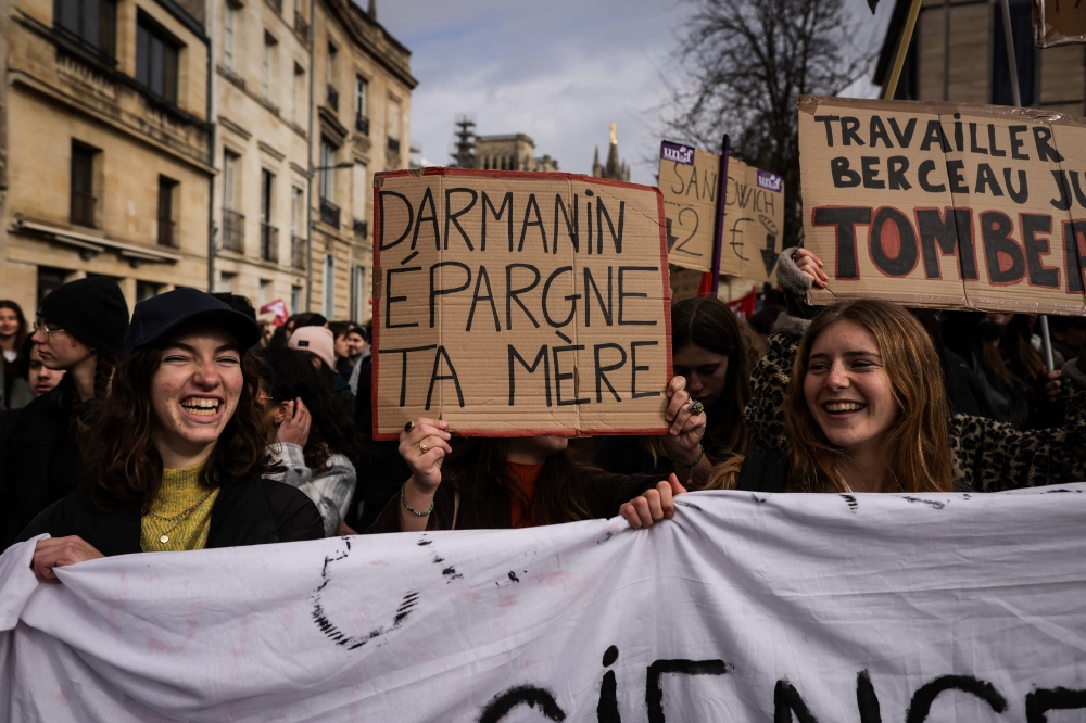 A protester (centre) holds a placard reading 