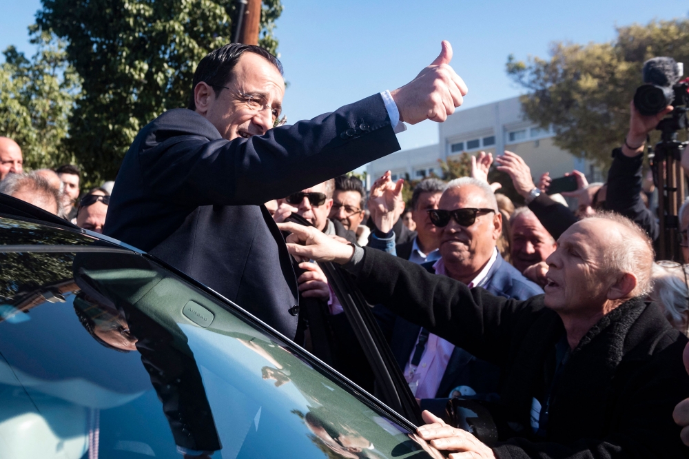 Former Cypriot foreign minister and presidential candidate Nikos Christodoulides greets supporters as he arrives to cast his vote at the Geroskypou polling centre in the western Paphos district, on February 12, 2023. (Photo by Iakovos Hatzistavrou / AFP)