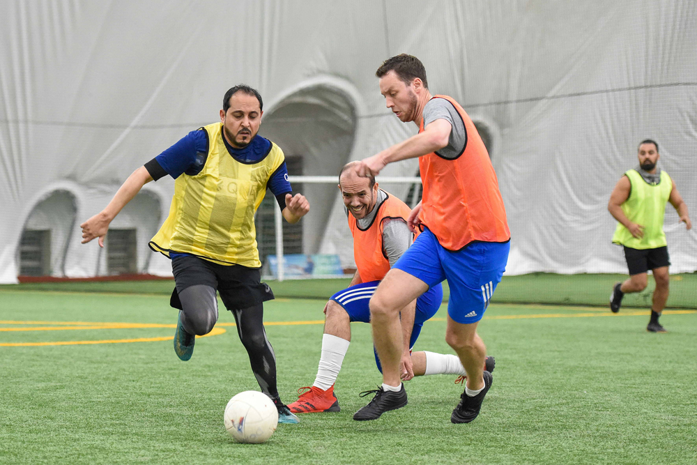 Employees of QNB taking part in a football match to mark the National Sport Day.