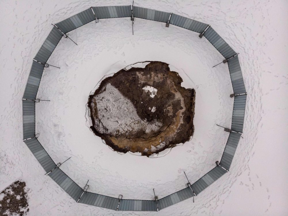 This aerial view from February 7, 2023 shows the collapsed ground surrounded by a metal barrier at the local football pitch in Trzebinia, Poland. Photo by Wojtek RADWANSKI / AFP