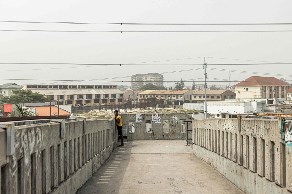 A woman looks over a bridge in Lagos on February 18, 2023, ahead of the Nigerian presidential election scheduled for February 25, 2023. (Photo by Patrick Meinhardt / AFP)
