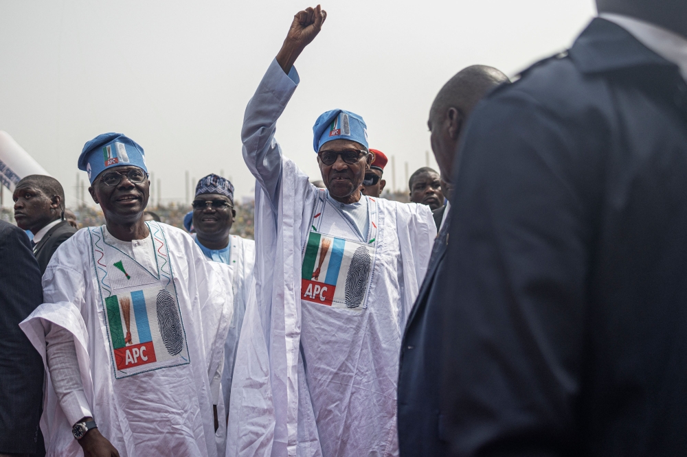 President of Nigeria Muhammadu Buhari (2nd R) raises his fist as he arrives at the All Progressives Congress (APC campaign rally at Teslim Balogun Stadium in Lagos on February 21, 2023 ahead of the Nigerian presidential election scheduled for February 25, 2023. (Photo by Michele Spatari / AFP)