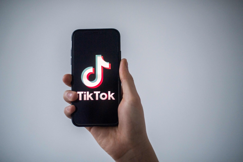 In this file photo taken on January 21, 2021 in Nantes, western France, a man shows a smartphone with the logo of Chinese social network Tik Tok. Photo by LOIC VENANCE / AFP