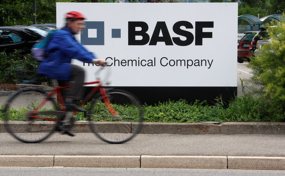 A cyclist rides his bike past the entrance of the BASF plant and former Ciba production site in Schweizerhalle near Basel, Switzerland July 7, 2009. REUTERS/Christian Hartmann
