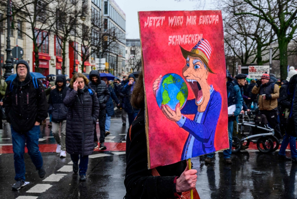 Under snow a demonstrator displays a placard reading: 