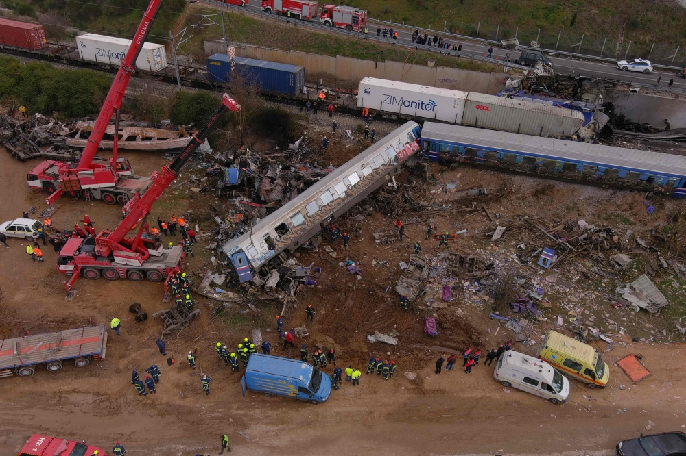 This aerial drone photograph taken on March 1, 2023, shows emergency crews examining the wreckage after a train accident in the Tempi Valley near Larissa, Greece. (Photo by STRINGER / AFP)