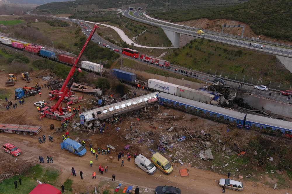 This aerial drone photograph taken on March 1, 2023, shows emergency crews examining the wreckage after a train accident in the Tempi Valley near Larissa, Greece. (Photo by STRINGER / AFP)