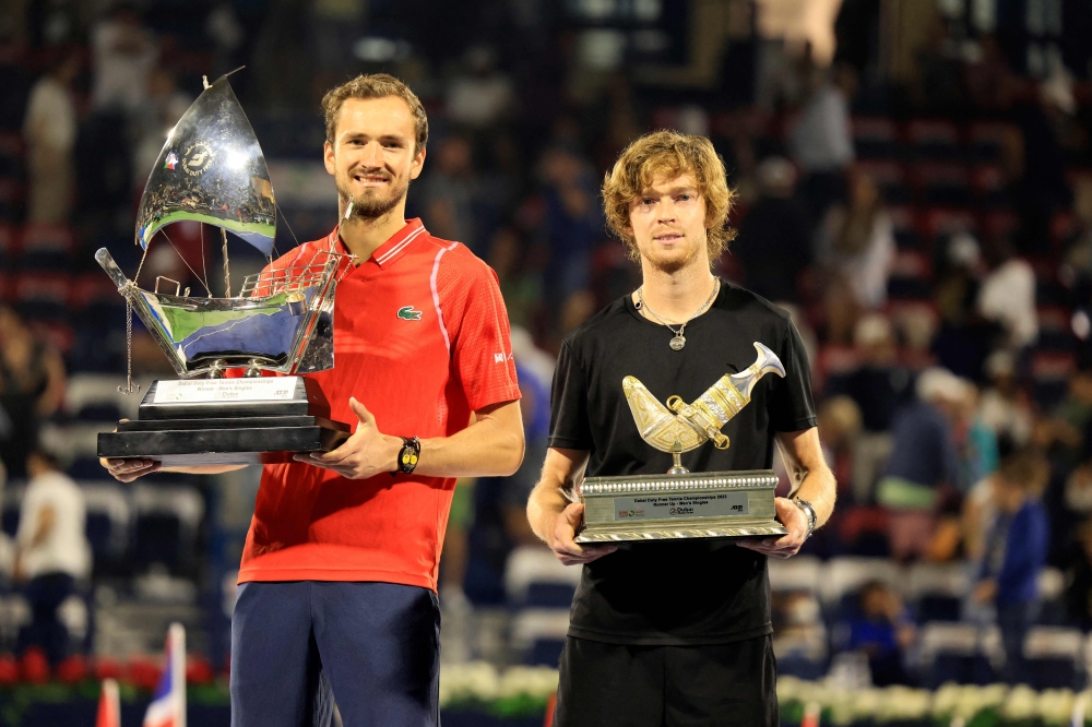 Russia's Daniil Medvedev (left) and Andrey Rublev pose with their trophies after the former won the ATP Dubai Duty Free Tennis Championship final match in Dubai, on March 4, 2023. (Photo by Karim SAHIB / AFP)
