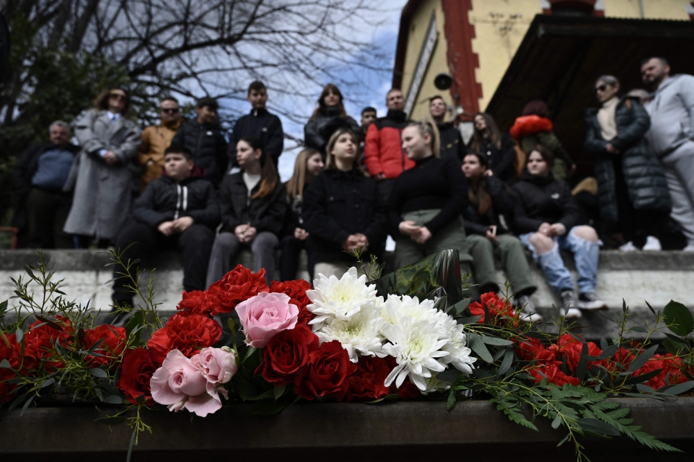 A photo shows flowers layed on the tracks at the railway station of Rapsani, north Greece, on March 5, 2023, during a commemorative gathering for the victims of a deadly train crash which killed 57. Photo by Sakis MITROLIDIS / AFP