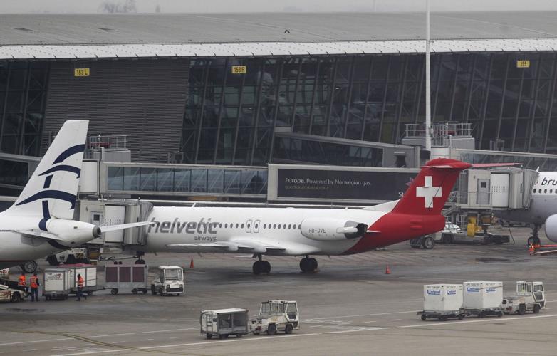 Baggage carts make their way past a Helvetic Airways aircraft from which about $50 million worth of diamonds were stolen on the tarmac of Brussels international airport, on Feb. 19, 2013.