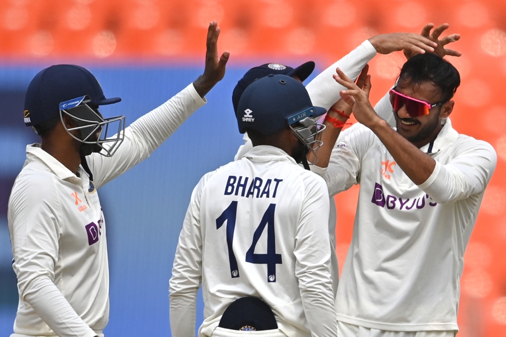 India's Axar Patel (R) celebrates with teammates after taking the wicket of Australia's Travis Head (not pictured) during the fifth day of the fourth and final Test cricket match between India and Australia at the Narendra Modi Stadium in Ahmedabad on March 13, 2023. (Photo by Punit Paranpe / AFP)