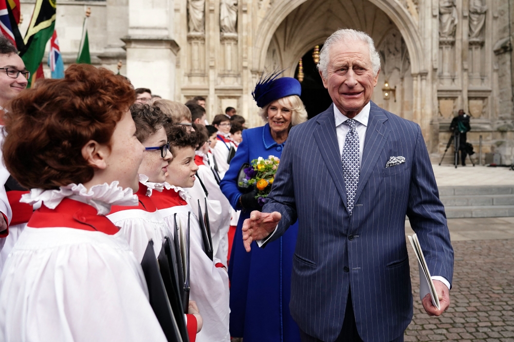 Britain's King Charles III (right) and Britain's Camilla, Queen Consort reacts as they meet with choristers following the Commonwealth Day service ceremony, at Westminster Abbey, in London, on March 13, 2023. (Photo by Jordan Pettitt / POOL / AFP)