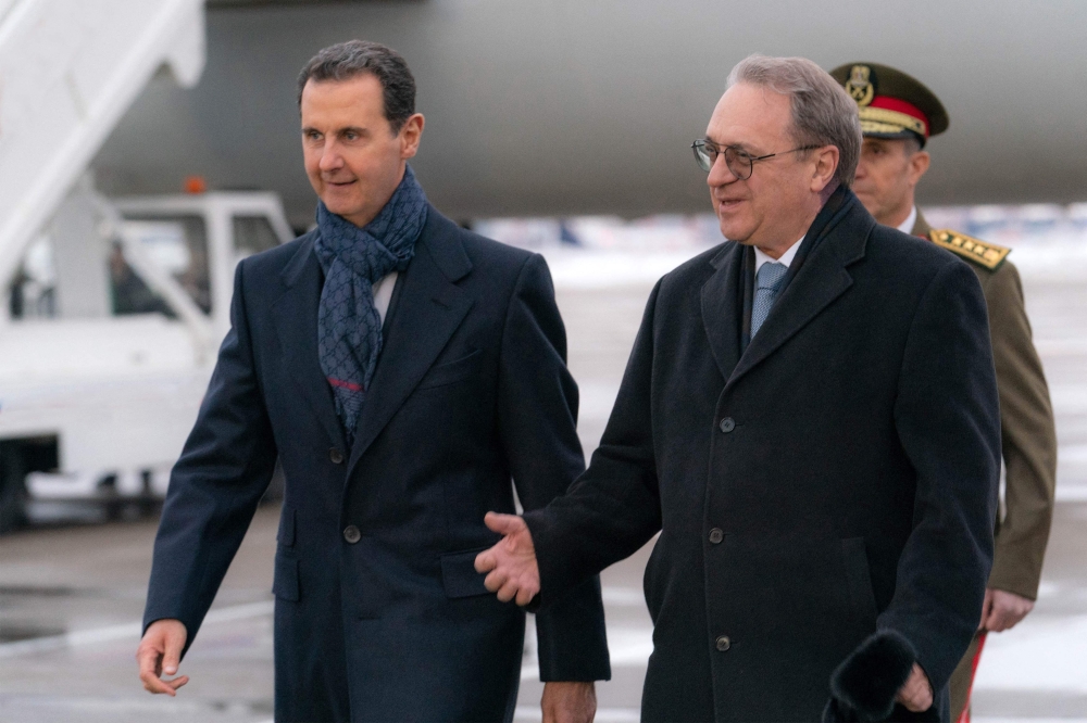 This handout picture released by the official Syrian Arab News Agency (SANA) shows Syria's President Bashar al-Assad being received by the Russia's Deputy Foreign Minister and the Russian president's special representative Mikhail Bogdanov upon arrival in Moscow on March 14, 2023. (Photo by SANA / AFP) 