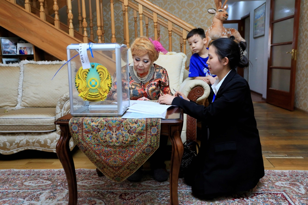 A woman votes at her home during parliamentary elections in Almaty on March 19, 2023.  (Photo by Ruslan PRYANIKOV / AFP)