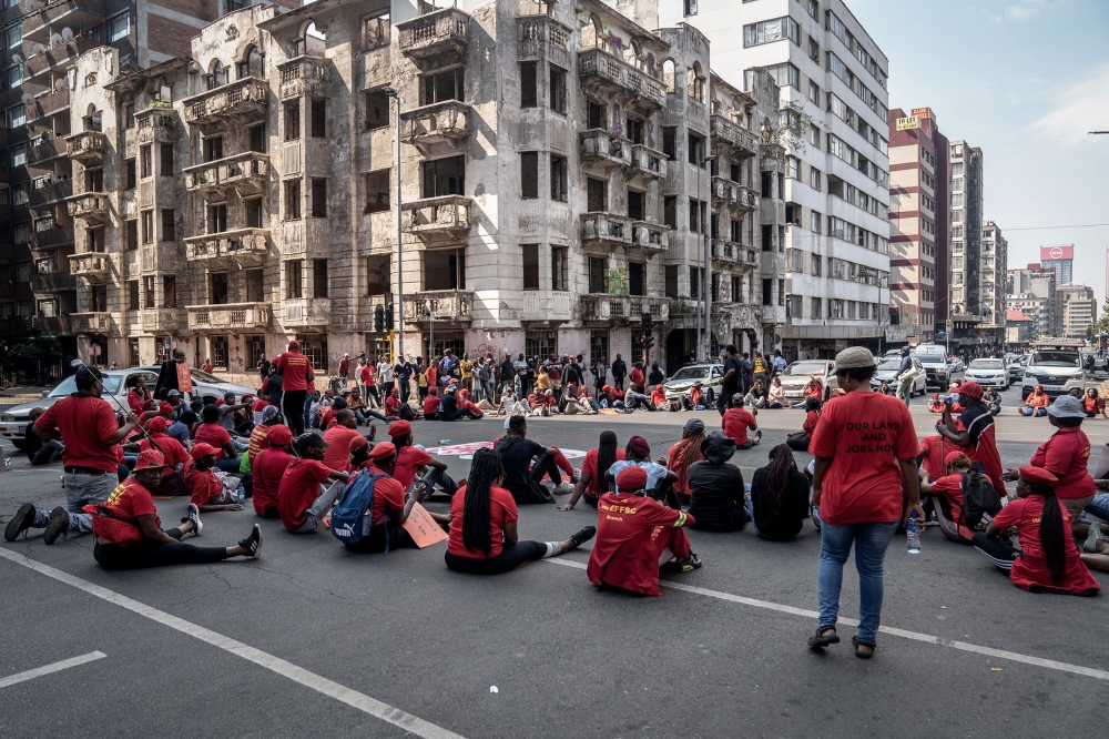 Members of the the Economic Freedom Fighters (EFF) stage a sit down on a street in Hillbrow, Johannesburg on March 20, 2023 during a 