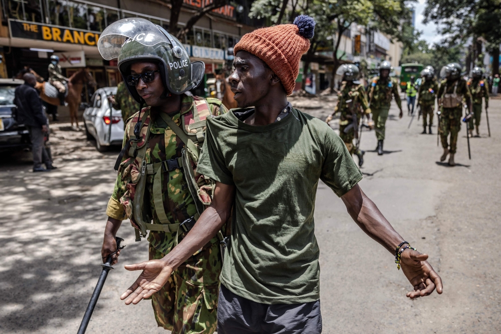 A Kenyan Police officer arrests a protester following clashes with opposition supporters in Nairobi, Kenya on March 20, 2023.  (Photo by Luis Tato / AFP)