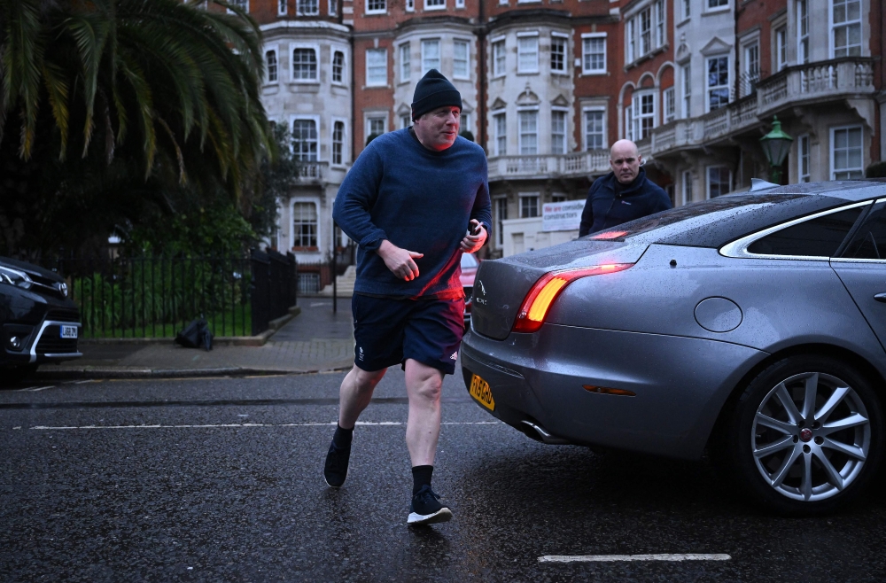 Former British Prime Minister Boris Johnson returns to his house after a run, in London on March 22, 2023. (Photo by JUSTIN TALLIS / AFP)