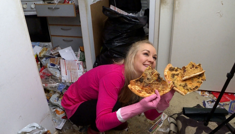 This video grab taken on January 19, 2023 shows Finnish TikTok cleanfluencer Auri Kananen with a rotten pizza as she is tidying up a pile of trash and food remains in a flat in Helsinki, Finland. Photo by Elias HUUHTANEN / AFP