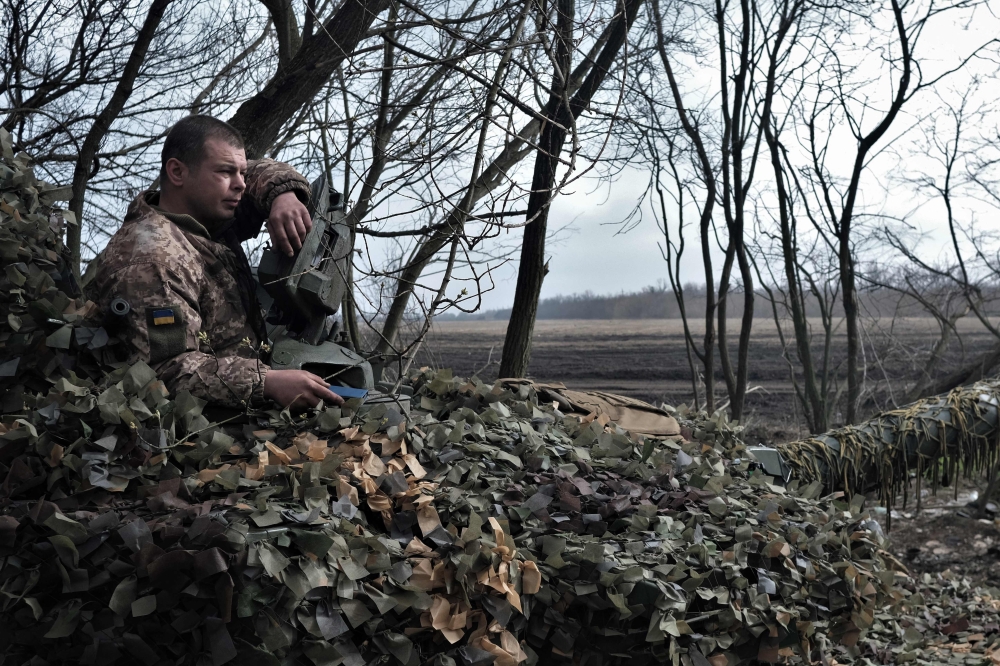 A Ukrainian serviceman sits on the T-72 tank on the front line near Bakhmut, on March 26, 2023, amid the Russian invasion of Ukraine. (Photo by Sergey SHESTAK / AFP